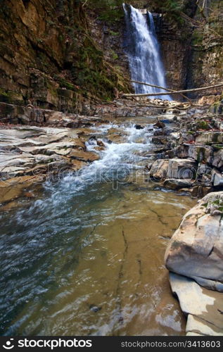 High mountain waterfall in dark wild Carpathian forest (Manjava, Ivano-Frankivsk Region, Ukraine).