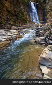 High mountain waterfall in dark wild Carpathian forest (Manjava, Ivano-Frankivsk Region, Ukraine).