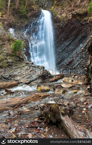 High mountain waterfall in wild Carpathian forest (Guk Waterfall, Ivano-Frankivsk Region, Ukraine).