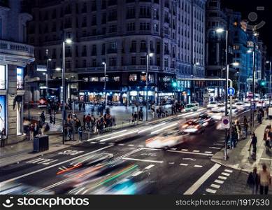 High perspective night time lapse view of busy pedestrian and vehicle traffic on Gran Via street in central Madrid, Spain