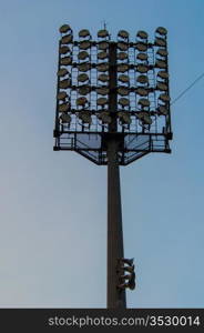 high-powered stadium floodlights seen against a pretty sky