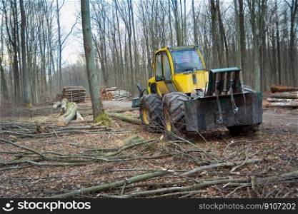 High-powered yellow tractor with rope winch standing in the forest