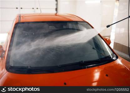 High pressure water on the car, wash service. Vehicle cleaning, carwash station, car-wash business. High pressure water on the car
