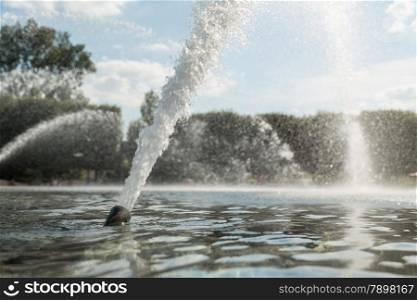 High pressured water gushing out of a pipe in a fountain