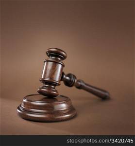 High quality wooden gavel and block on brown background. Short depth-of-field.