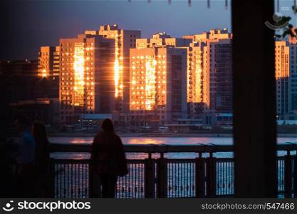 high-rise buildings in the sunset and the silhouette of a man in the foreground.. high-rise buildings in the sunset and the silhouette of a man in the foreground