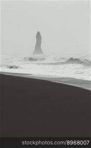 High rock in stormy waves monochrome landscape photo. Beautiful nature scenery photography with fog on background. Idyllic scene. High quality picture for wallpaper, travel blog, magazine, article. High rock in stormy waves monochrome landscape photo