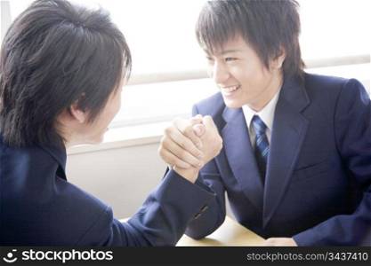 High school boy doing arm wrestle with friend
