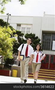 High School Couple Walking in Front of School