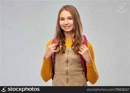 high school, education and people concept - smiling teenage student girl with backpack over grey background. smiling teenage student girl with backpack