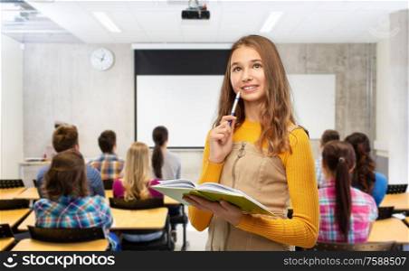 high school, education and vision concept - happy smiling teenage student girl with book and pen over classroom background. smiling student girl with book and pen at library