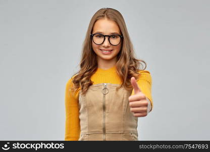 high school, education and vision concept - smiling teenage student girl in glasses over grey background. smiling teenage student girl in glasses