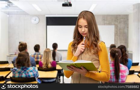 high school, education and vision concept - teenage student girl with book and pen over classroom background. student girl with book and pen at library