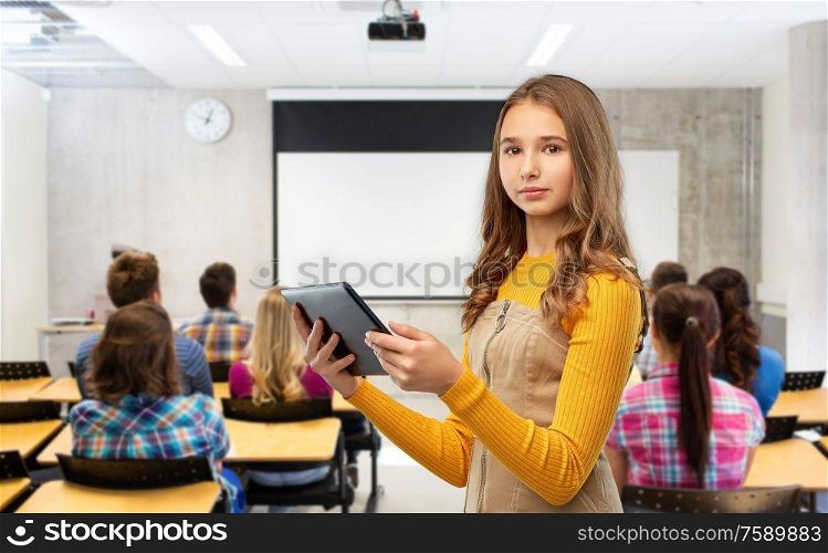 high school, education, technology and people concept - teenage student girl using tablet computer over classroom background. student girl using tablet computer at school