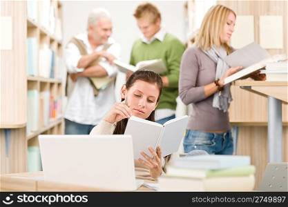 High school library - Student with book and laptop