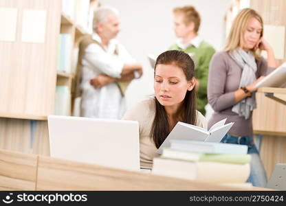 High school library - Student with book and laptop