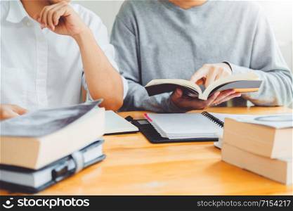 High school or college students studying and reading together in library