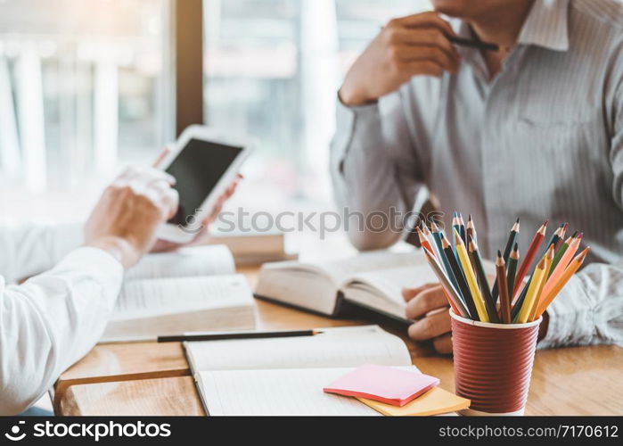 High school or college students studying and reading together in library