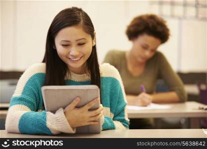 High School Student At Desk In Class Using Digital Tablet