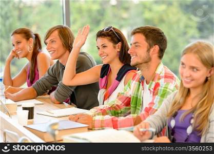 High-school student raising her hand in class lesson teenagers study