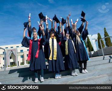 high school students graduates tossing up hats over blue sky.