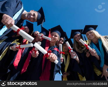 high school students graduates tossing up hats over blue sky.