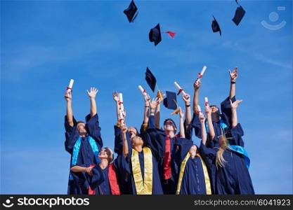 high school students graduates tossing up hats over blue sky.