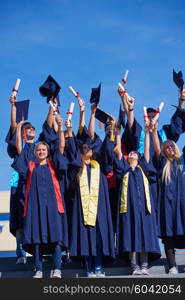 high school students graduates tossing up hats over blue sky.