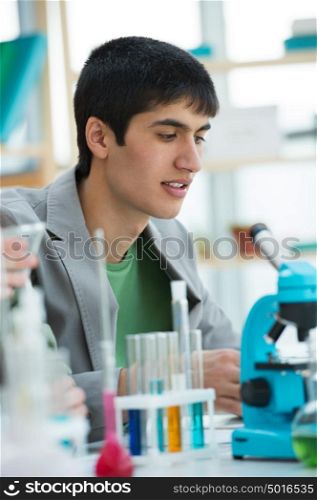 High School students. Handsome mixed race guy working at laboratory class