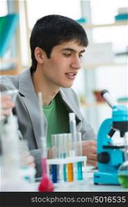 High School students. Handsome mixed race guy working at laboratory class