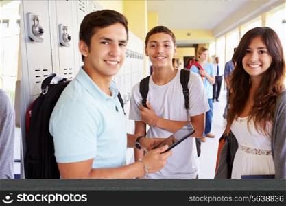 High School Students Standing By Lockers With Mobile Phone