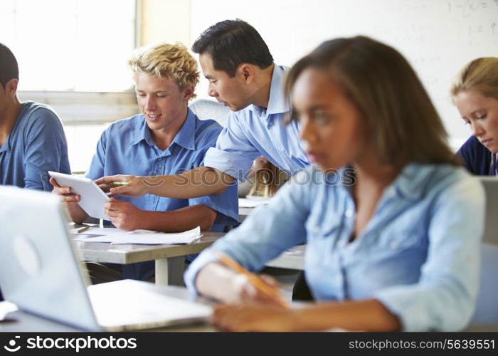 High School Students With Laptops And Digital Tablets