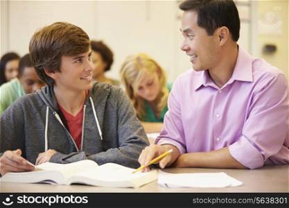 High School Teacher Helping Student With Written Work