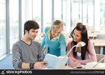 High school - three students with book in classroom