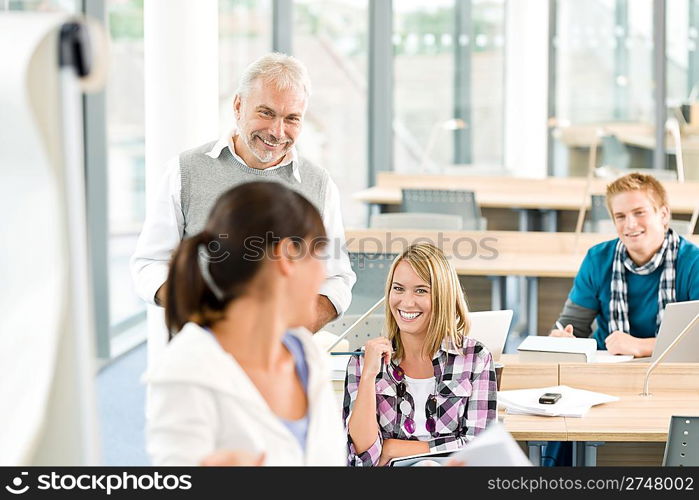 High school - three students with mature professor in classroom