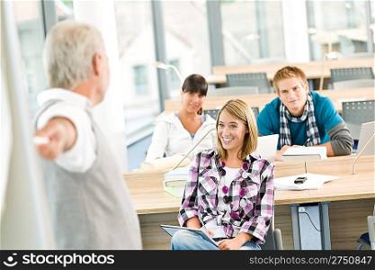 High school - three students with mature professor in classroom