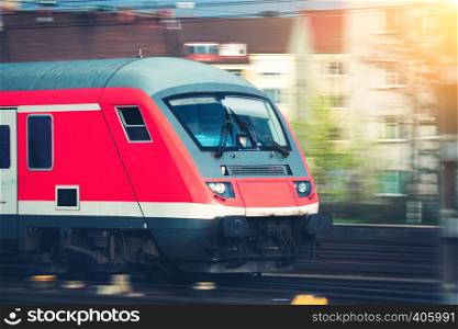 High speed passenger train on tracks in motion at sunset. Commuter train. Railway station in Nuremberg, Germany. Railroad with vintage toning