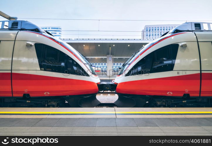 High speed trains on the railway station in Vienna, Austria. Beautiful red modern intercity passenger train on the railway platform. Railroad in Europe. Commercial transportation. Railway travel