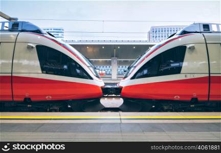 High speed trains on the railway station in Vienna, Austria. Beautiful red modern intercity passenger train on the railway platform. Railroad in Europe. Commercial transportation. Railway travel