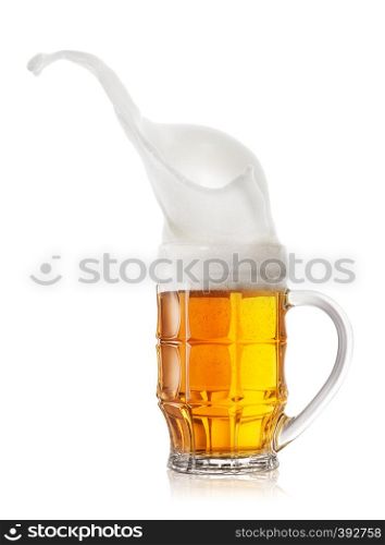 High splash of froth in a mug of beer. Isolated on white background.. High splash of froth in a mug of bee