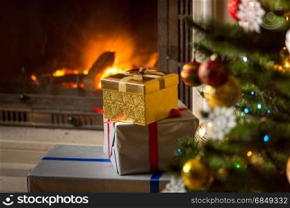 High stack of Christmas presents with burning fireplace