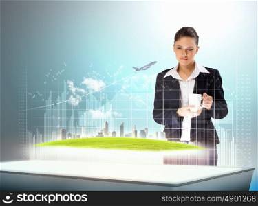 High-tech in business. Image of young businesswoman holding cup standing against high-tech picture