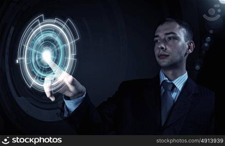 High technologies. Young businessman pressing high tech circle icon on media screen