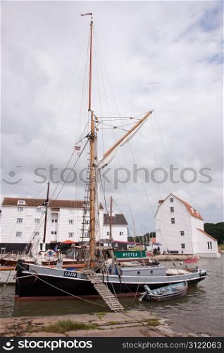 High tide at the Tidemill and quay at Woodbridge,Suffolk,UK with a gaff rigged workboat in the foreground