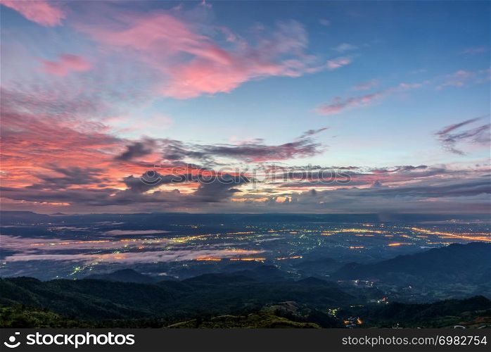 High view beautiful nature landscape of colorful sky during the sunrise see the lights of the road and city at Phu Thap Berk viewpoint famous tourist attractions of Phetchabun Province, Thailand. Phu Thap Berk Viewpoint at the sunrise