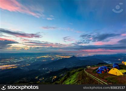 High view beautiful nature landscape of colorful sky during the sunrise, see the lights of the road and city from the campsite at Phu Thap Berk viewpoint, Phetchabun Province, Thailand. Phu Thap Berk during the sunrise