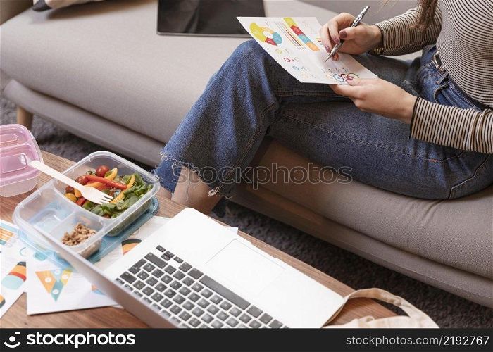 high view hungry businesswoman eating reviewing chart