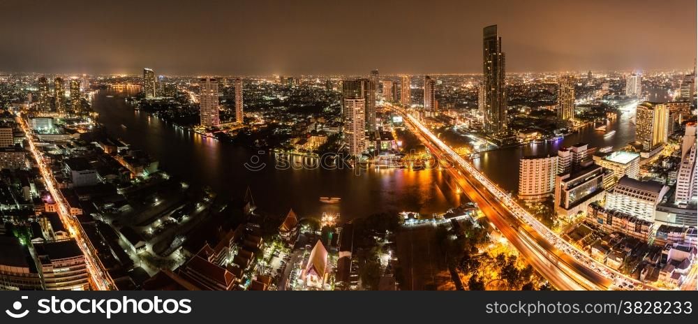 High view of Bangkok city with modern building and traffic at nigh along Chaopraya river