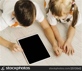 high view siblings using digital tablet