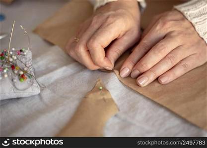 high view woman sewing with needle thread